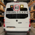 Photo of the rear of a 2024 Mercedes Sprinter bus with Safebus SB001A surface mount New South Wales TS150 school bus lights and signage installed
