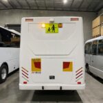 Photo of the rear of a 2024 Isuzu iBus bus with Victorian Safebus SB001A surface mount school bus lights and signage