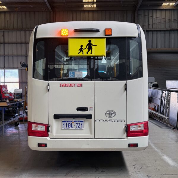 Photo of the rear of a 2024 4th generation B80 Toyota Coaster bus with Safebus SB001A surface mount Victorian school bus lights and signage installed
