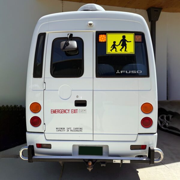 Photo of the rear of a 2024 5th generation BE7 Mitsubishi Rosa bus with Safebus SB001B window mount Victorian school bus lights and signage installed and tow bar