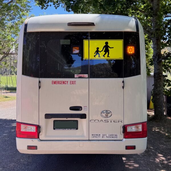 Photo of the rear of a 2024 4th generation B80 Toyota Coaster bus with Safebus SB001B window mount Victorian school bus lights and signage installed