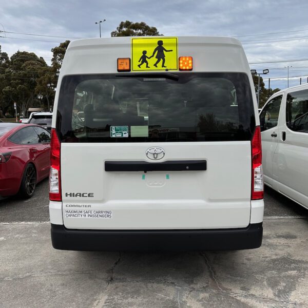 Photo of the rear of a Toyota HiAce Commuter bus with Victorian exterior mount school bus lights and mother & child sign installed