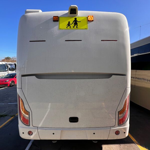 Photo of the rear of a 2024 Challenger bus with Victorian Safebus SB001A surface mount school bus lights and signage