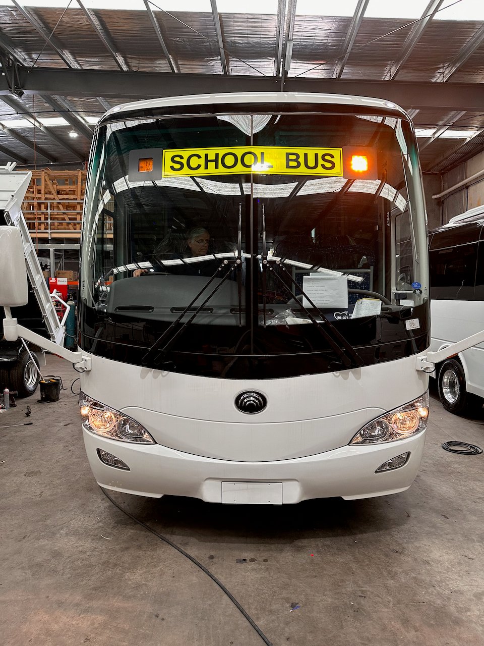 Photo of the front of a 57 seater Yutong D9 bus with Safebus SB001B window mount school bus lights and New South Wales signage installed and BF100 flasher unit