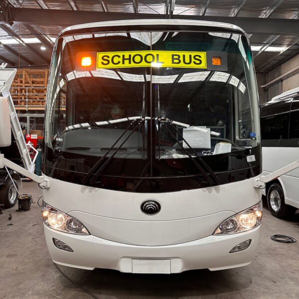 Photo of the front of a Yutong D9 bus with Safebus SB001B window mount school bus wig-wag lights and NSW TS150 signage installed