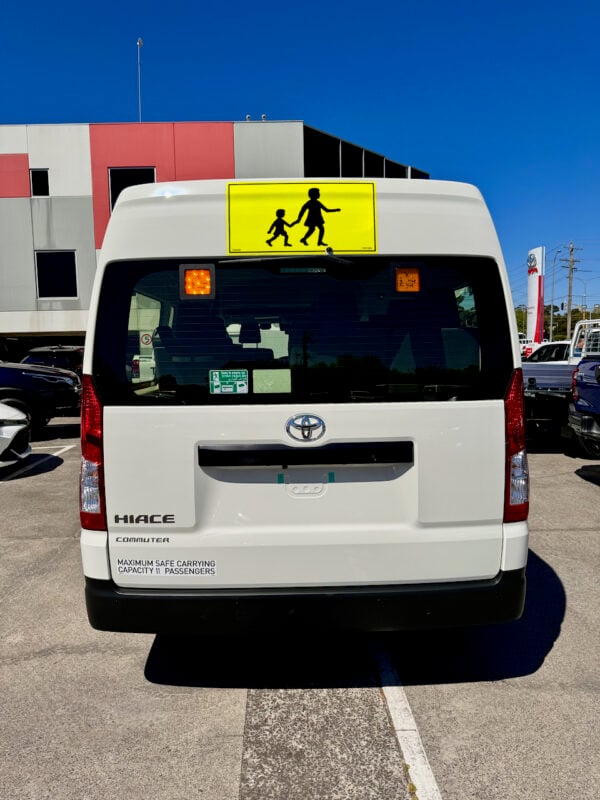 Photo of the rear of a 2023 6th generation Toyota HiAce Commuter bus with Safebus interior mount Victorian school bus lights and signage installed