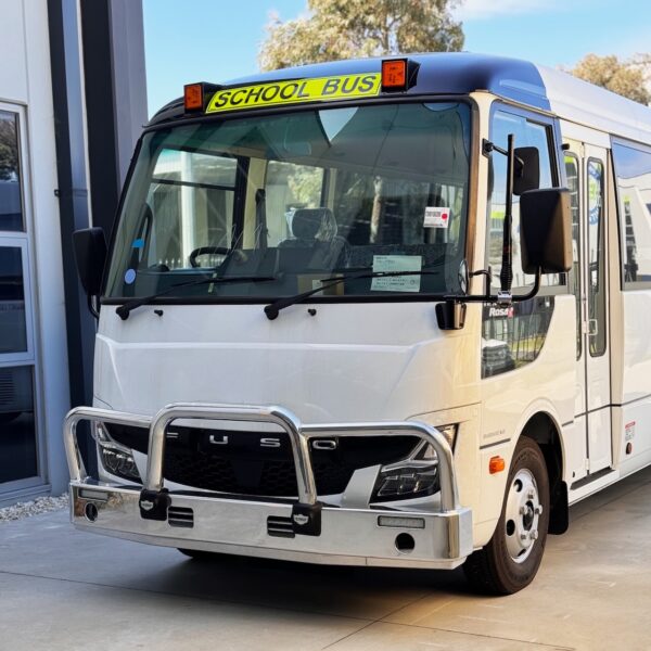 Two thirds photo of the front of a Mitsubishi Rosa bus with NSW TS150 school bus lights and signage installed