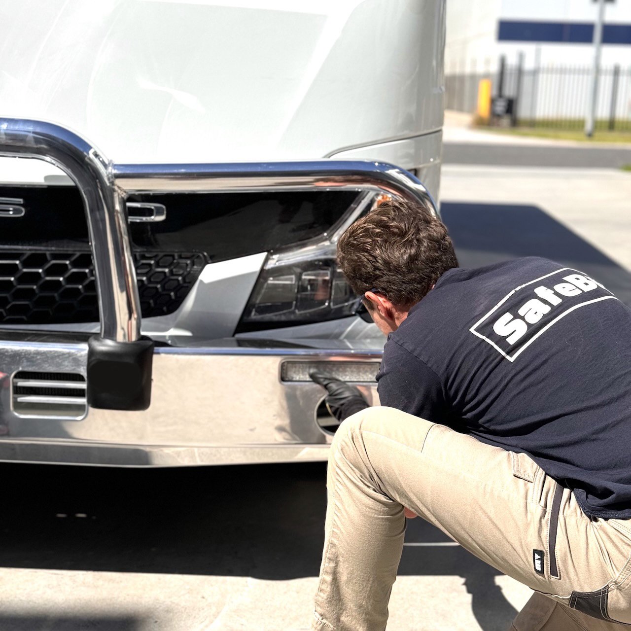 Photo of a Safebus employee working on the front of a 2024 5th generation BE7 Mitsubishi Rosa bus with a Safebus Bullbar fitted.