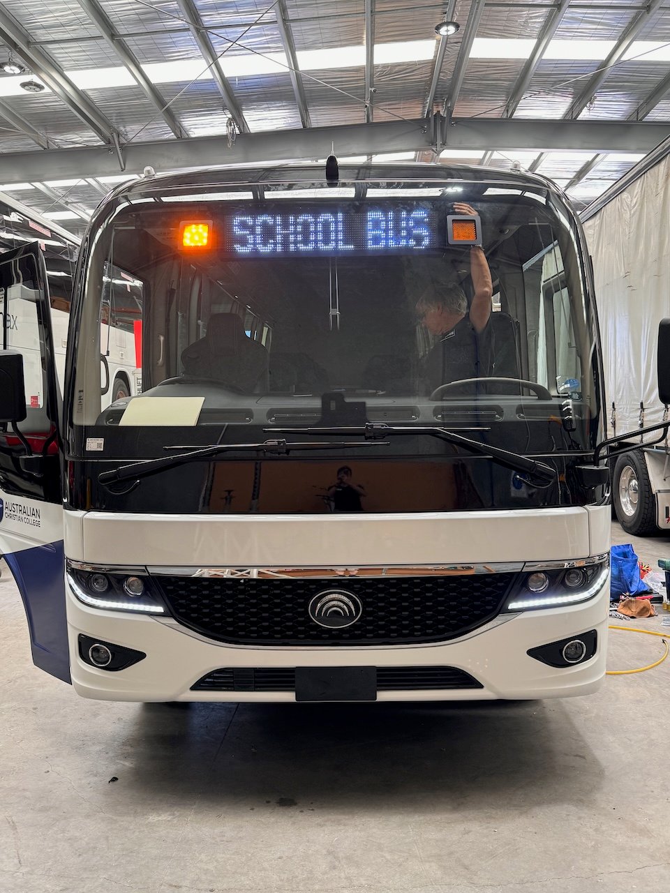 Photo of the front of a 2024 Yutong D7 bus with Safebus window mount school bus lights