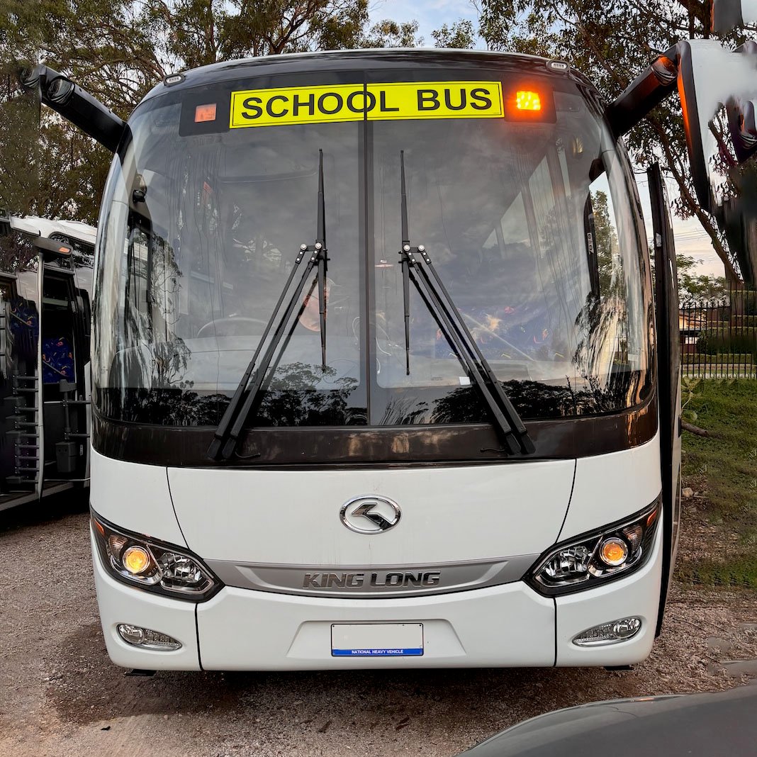 Photo of the front of a 57 seater King Long bus with Safebus SB001B window mount school bus lights and New South Wales signage installed