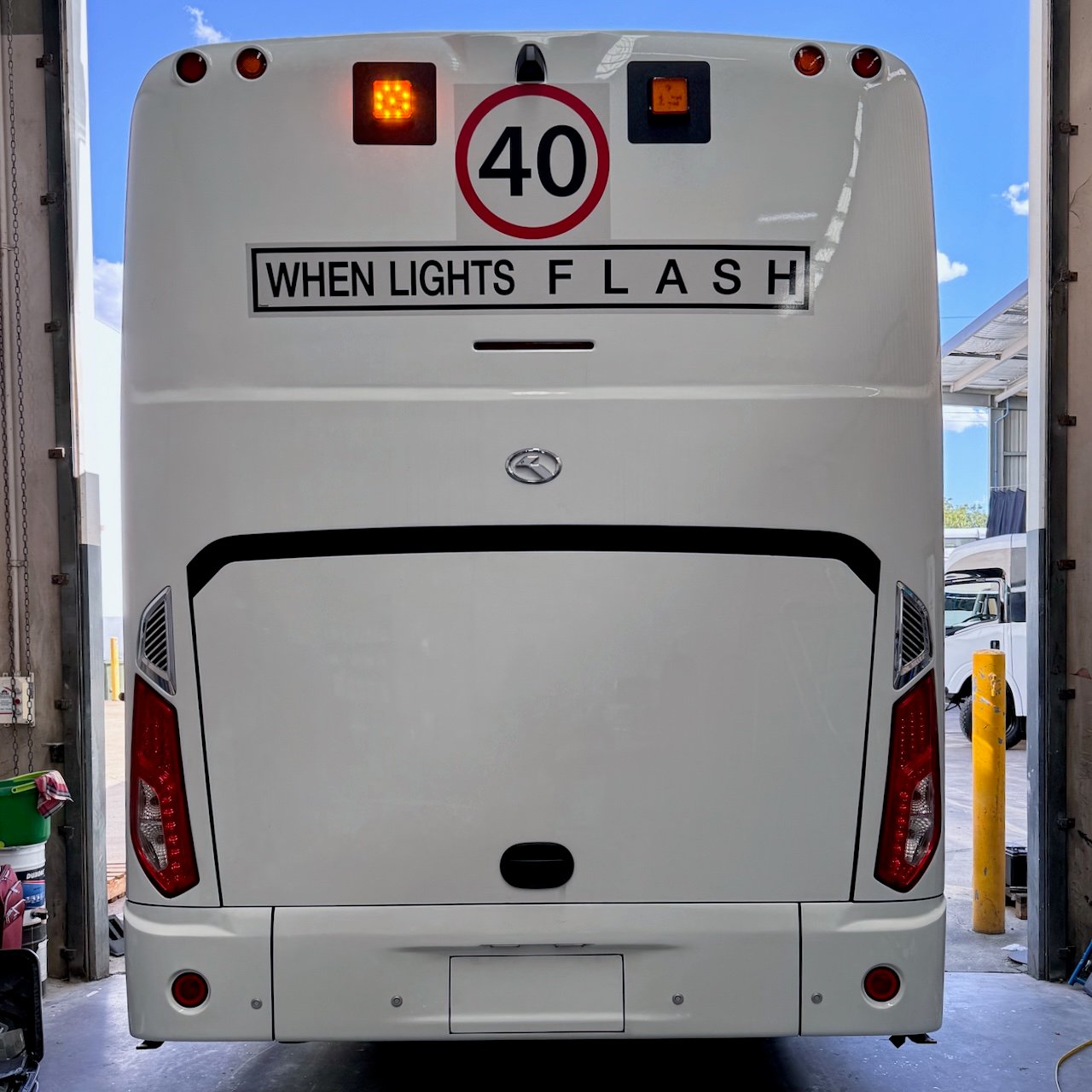 Photo of the rear of a King Long bus with Safebus SB001B window mount school bus lights and NSW TS150 signage installed