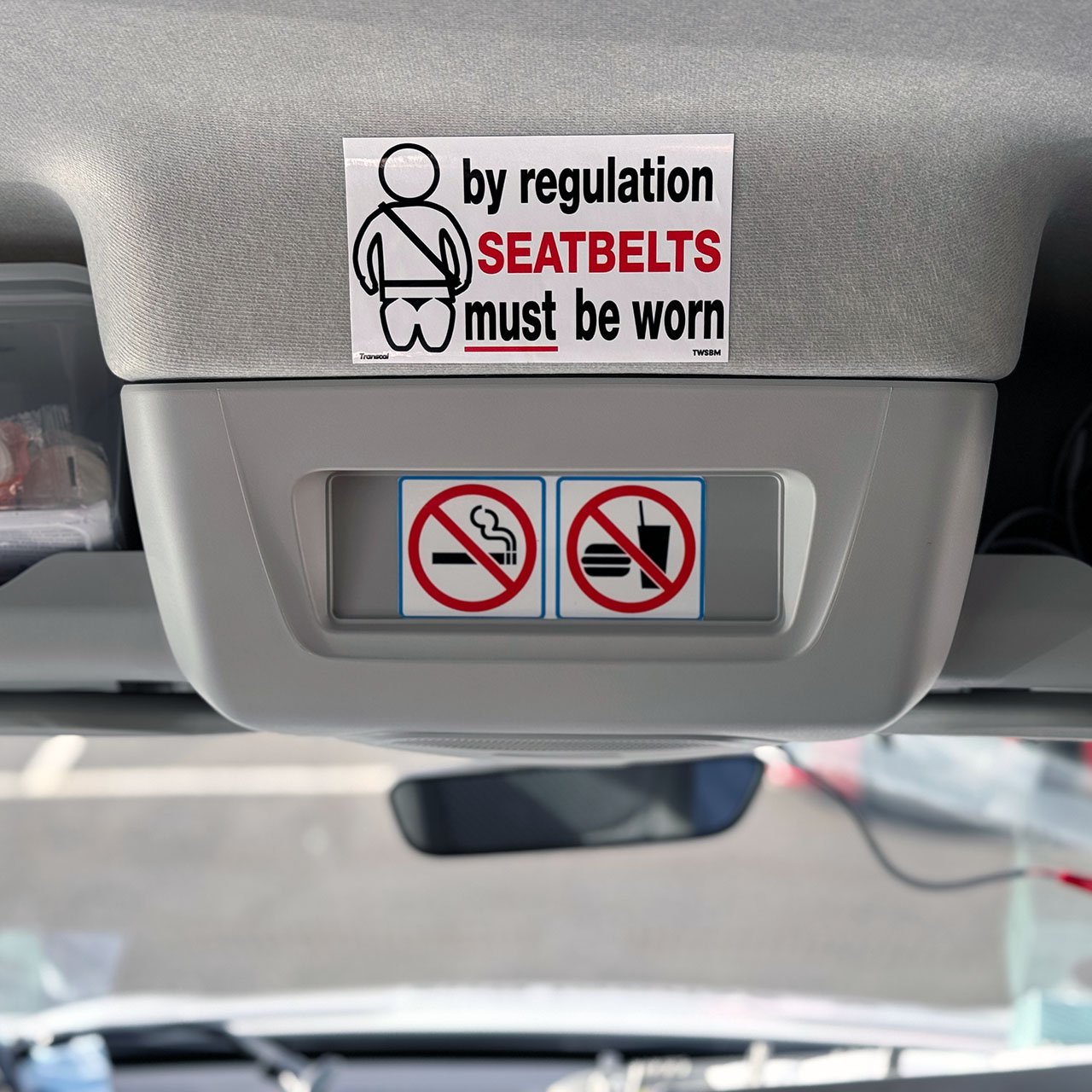 Photo of 2024 LDV interior with SafeBus 120x120mm No Smoking sticker, seatbelts must be worn sticker and no food eating or drinking sticker applied to the headboard