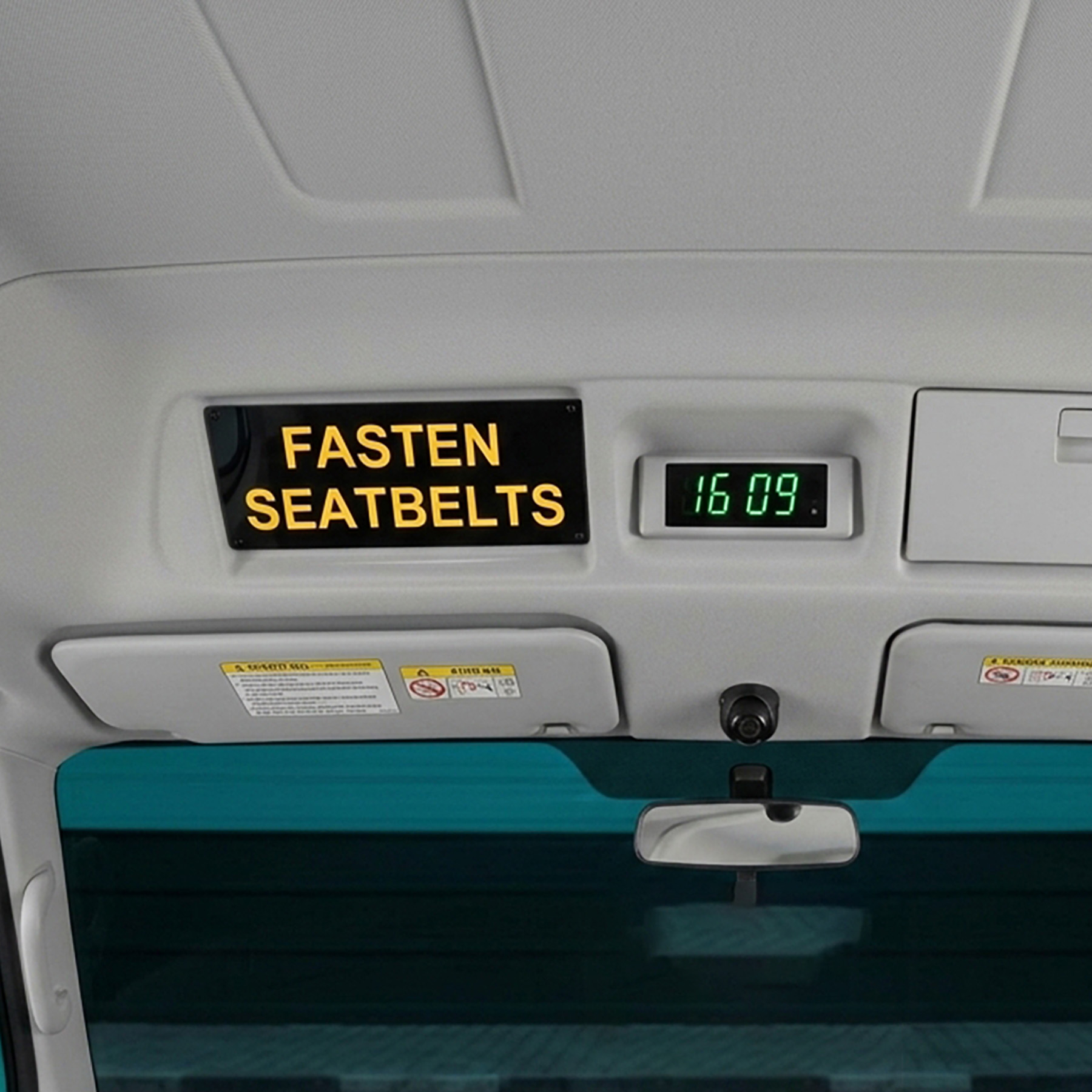 Illuminated Fasten Seatbelts sign mounted at the front of a bus passenger compartment for ADR 68/01