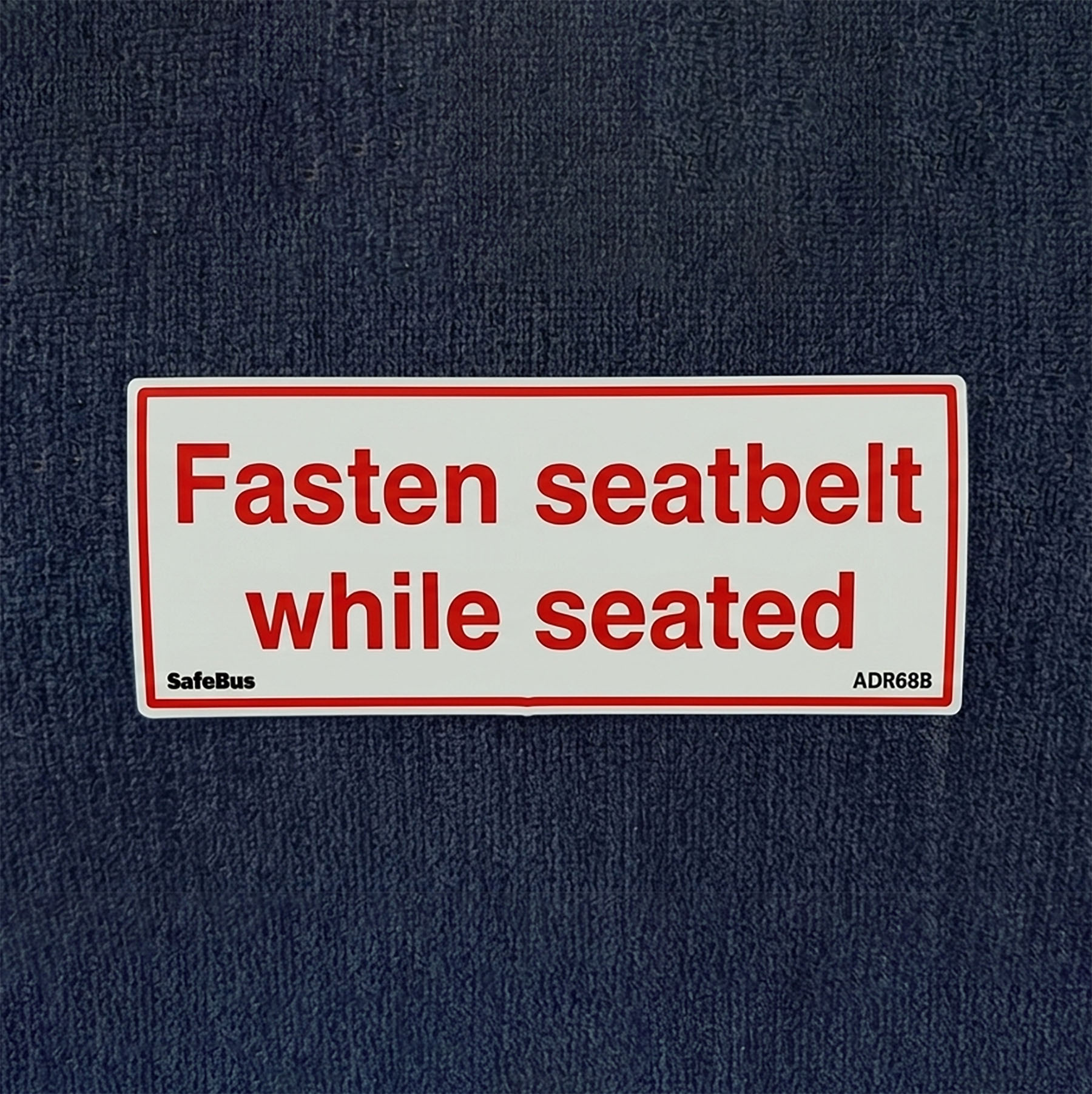 Fasten seatbelt while seated label on a bus seat back – ADR 68/01 clause 5.8.1